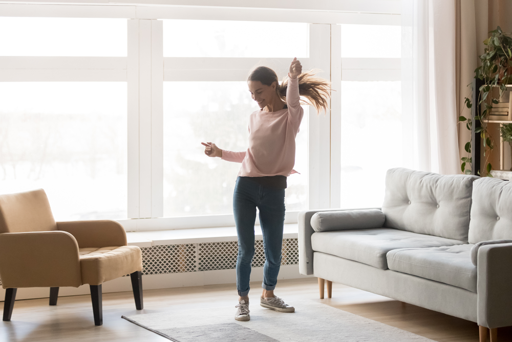 woman dancing in new apartment after moving out of state